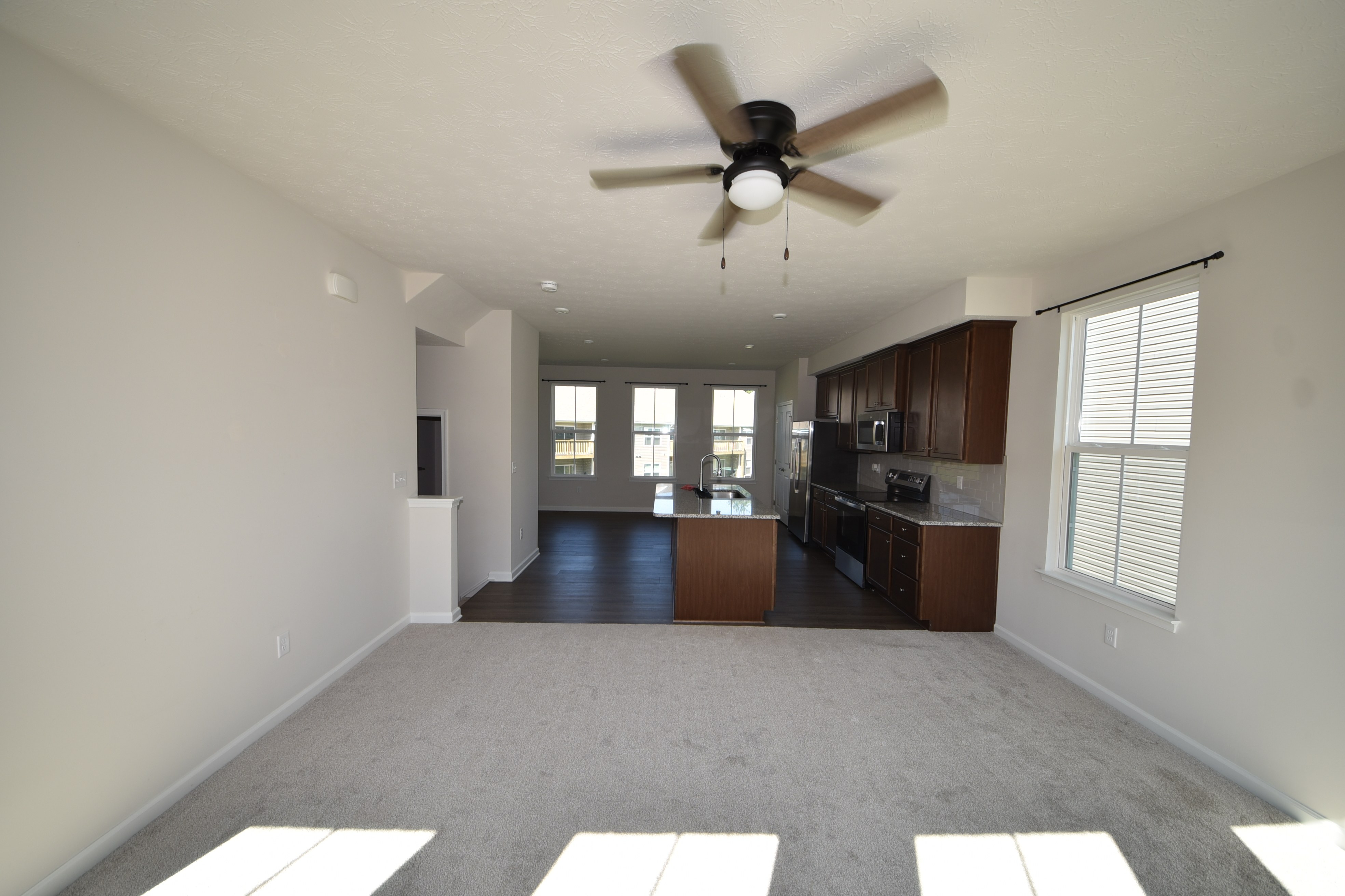 Open kitchen and living area with ceiling fan