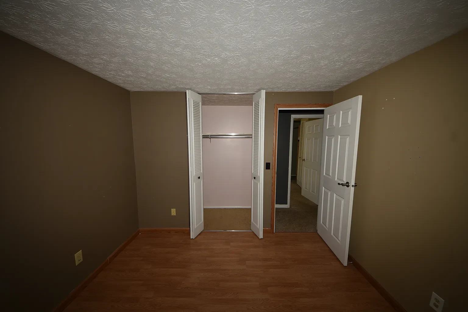 Bedroom with brown walls and open closet
