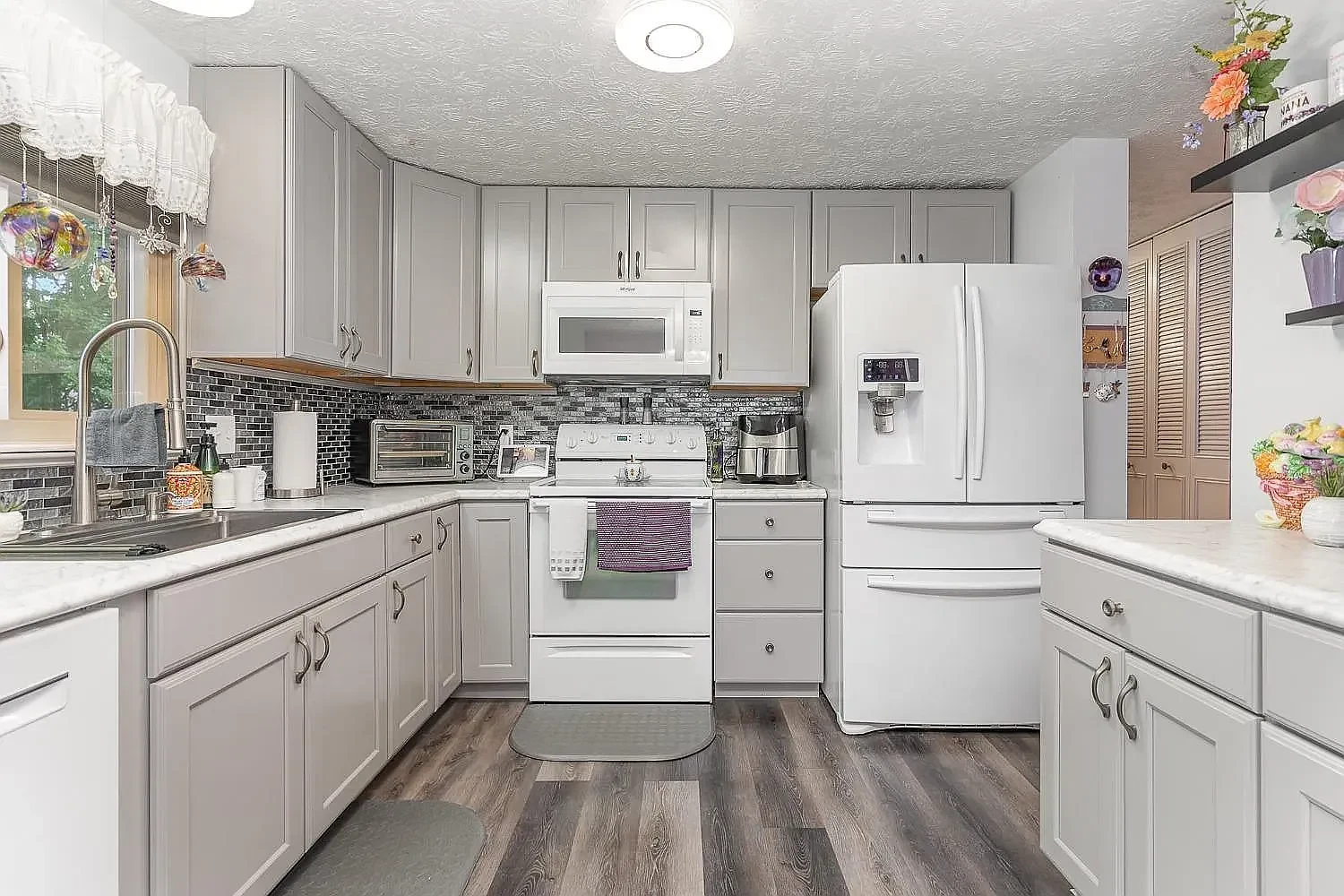 Kitchen with gray cabinets and white appliances