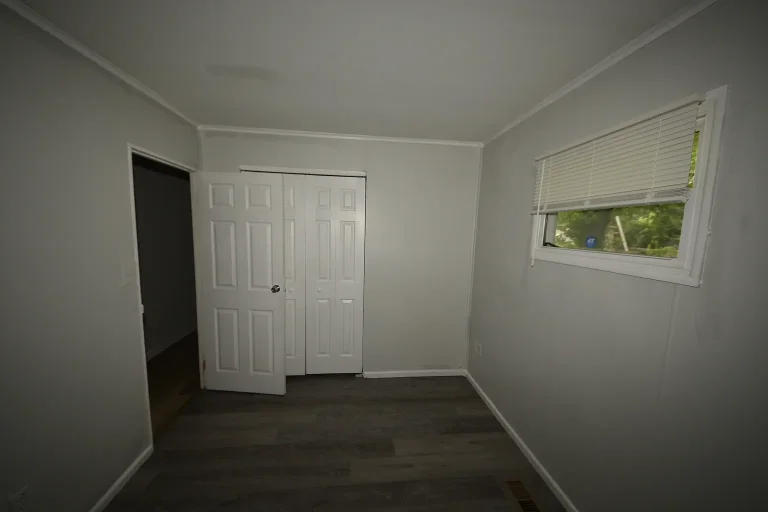 Bedroom with double-door closet and corner window